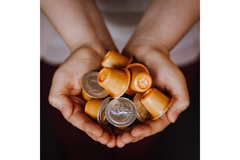 Image Two hands holding coffee capsules.